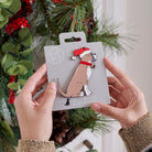 Boxer Christmas tree decoration held in hands on backing card — Father Christmas hat and jingle bell collar, dog lover gift by Sweet William Designs