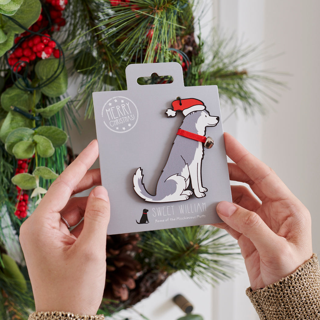 Husky Christmas tree decoration held in hands on backing card — Father Christmas hat and jingle bell collar, dog lover gift by Sweet William Designs