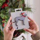 Lurcher Christmas tree decoration held in hands on backing card — Father Christmas hat and jingle bell collar, dog lover gift by Sweet William Designs