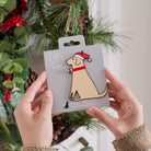Yellow Labrador Christmas tree decoration held in hands on backing card — Father Christmas hat and jingle bell collar, dog lover gift by Sweet William Designs