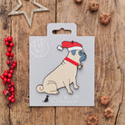 Pug Christmas decoration on backing card — wooden dog decoration with Father Christmas hat and jingle bell collar, festive dog lover gift by Sweet William Designs