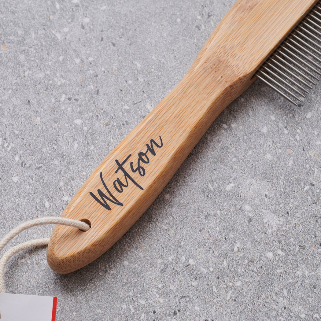 Close-up of personalised bamboo dog comb handle engraved with 'Watson' in script — metal-tooth grooming comb, dog lover gift by Sweet William Designs