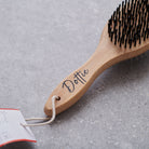 Close-up of bamboo double sided brush handle personalised with name in script — dog grooming gift by Sweet William Designs