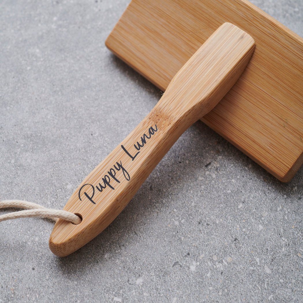 Close-up of bamboo slicker brush handle personalised with name — new puppy gift by Sweet William Designs