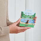 Black Labrador enamel dog pin held in hands on illustrated park backing card — gold-plated dog lover gift by Sweet William Designs