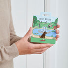 Chocolate Cockapoo / Labradoodle enamel dog pin held in hands on illustrated park backing card — gold-plated dog lover gift by Sweet William Designs