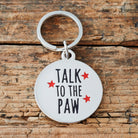 Close-up of 'Talk To The Paw' dog tag — silver-plated brass with red star design, personalised dog ID tag by Sweet William Designs 