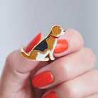 Close-up of a Beagle enamel pin held in hand, showing the detailed Beagle dog design by Sweet William Designs