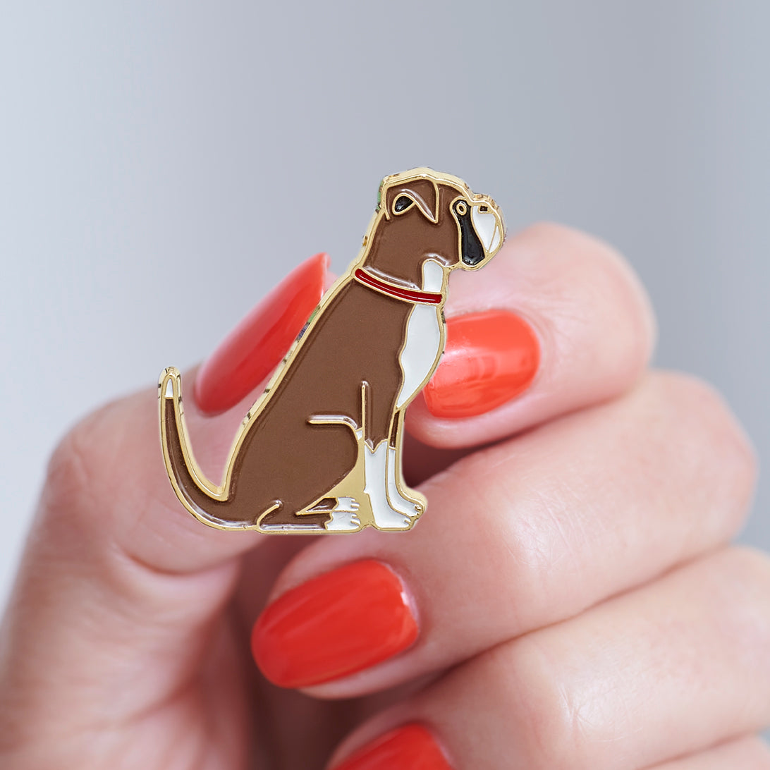 Close-up of a Boxer enamel pin held in hand, showing the detailed Boxer dog design by Sweet William Designs