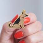 Close-up of a German Shepherd enamel pin held in hand, showing the detailed German Shepherd illustration by Sweet William Designs