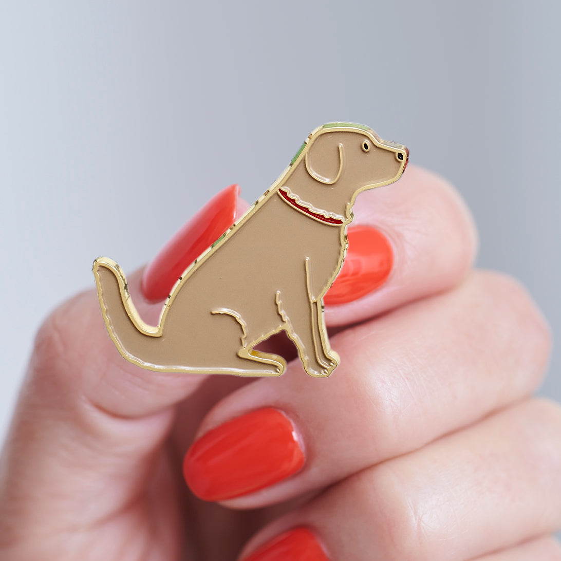 Close-up of a Golden Retriever enamel pin held in hand, showing the detailed Golden Retriever illustration by Sweet William Designs 