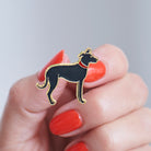 Close-up of a Lurcher enamel pin held in hand, showing the detailed Lurcher illustration by Sweet William Designs