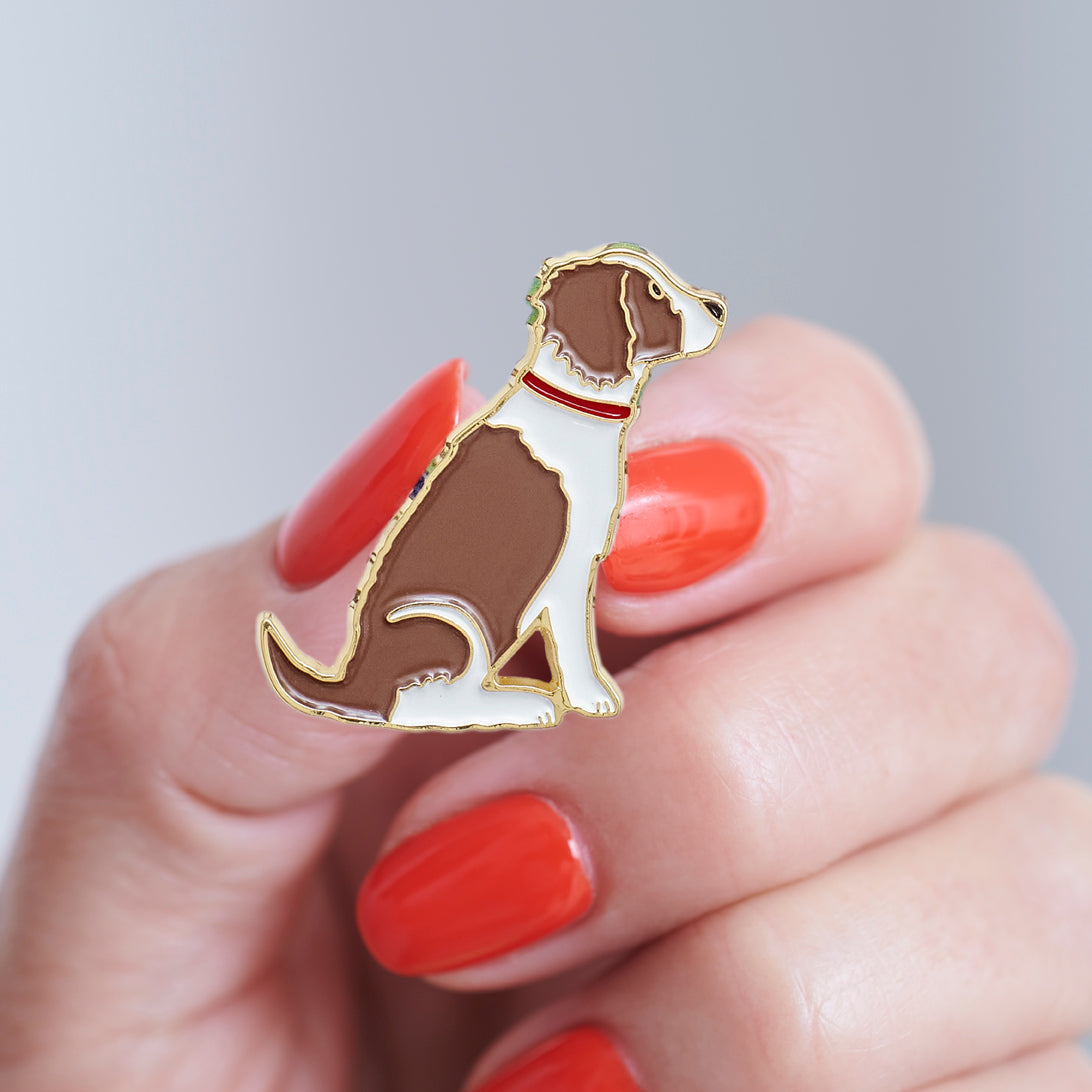 Close-up of a Liver & White Springer Spaniel enamel pin held in hand, showing the detailed Springer Spaniel illustration by Sweet William Designs