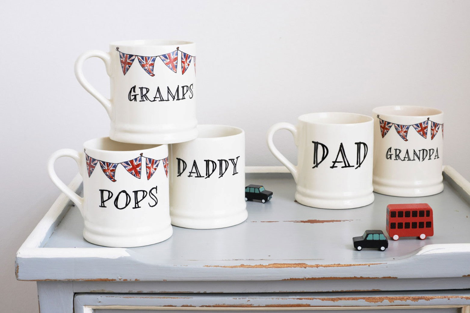 Group of ceramic grandfather mugs with hand-drawn Union Jack bunting, arranged as Father’s Day gifts