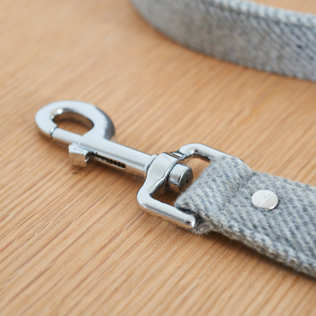 Close-up of the silver clasp on a grey tweed dog lead