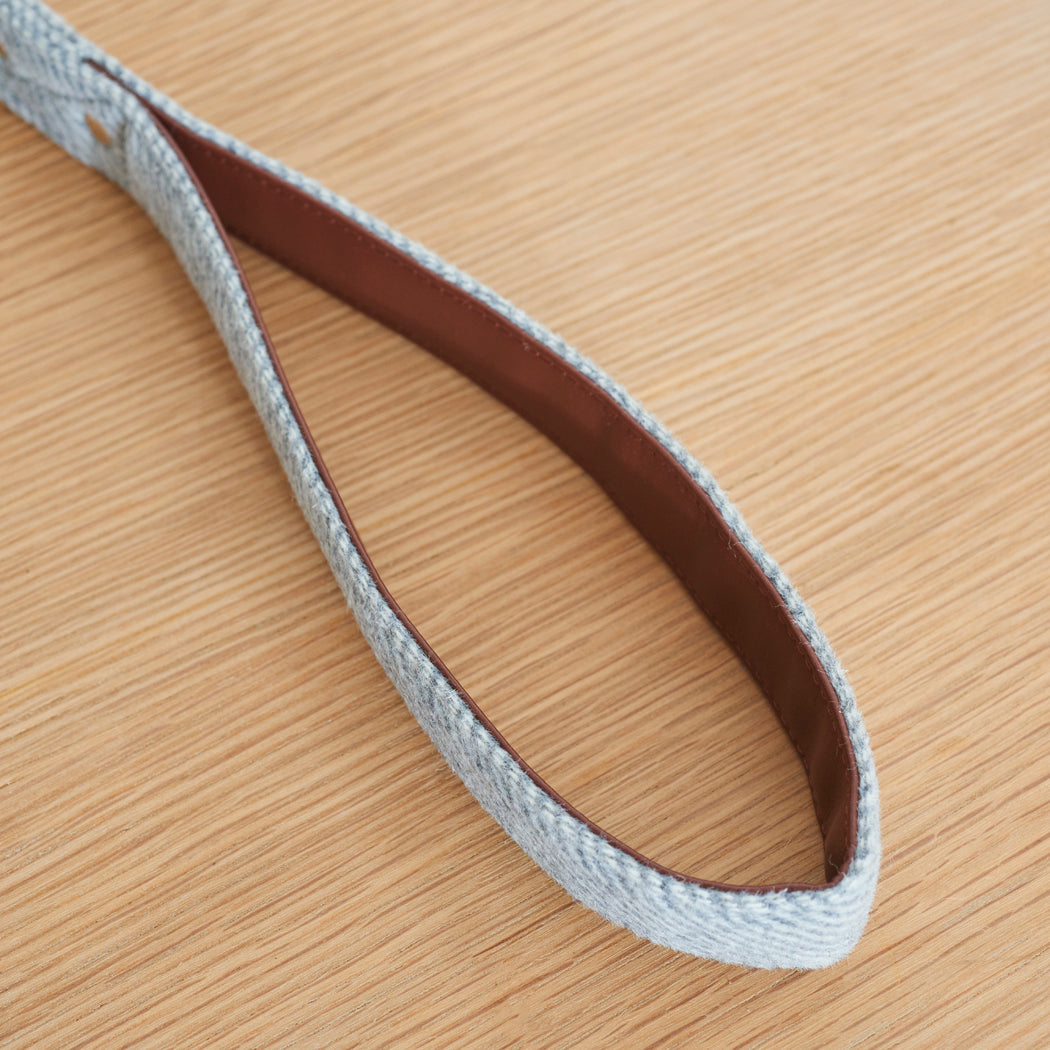 Close-up of the vegan leather-lined handle on a grey tweed dog lead