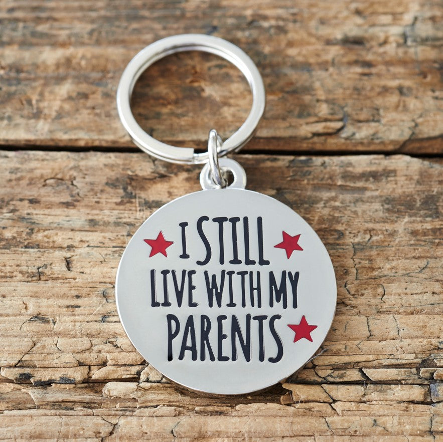 Close-up of 'I Still Live With My Parents' dog tag — silver-plated brass with red star design, personalised dog ID tag by Sweet William Designs