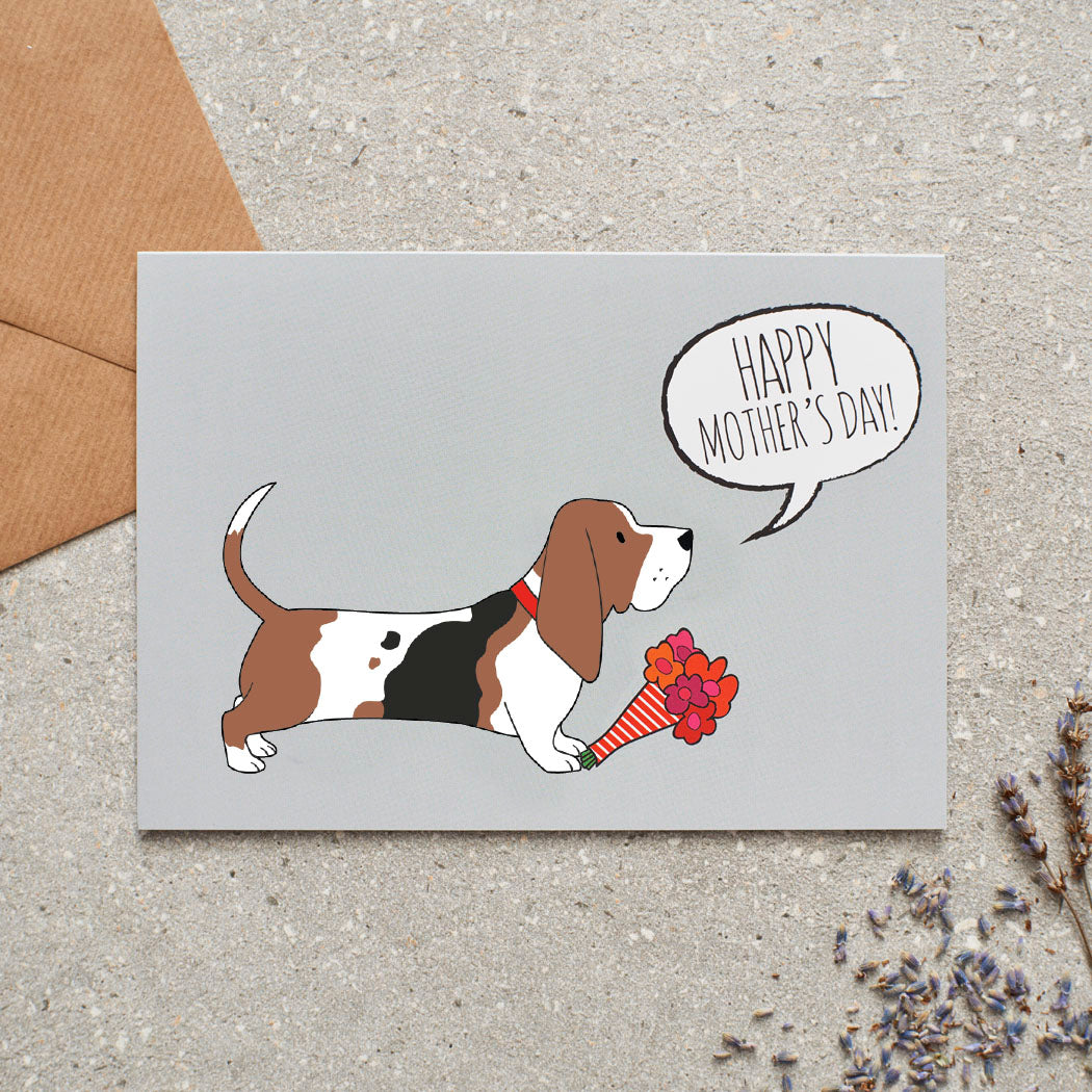 Basset Hound Mother's Day card featuring illustrated Basset Hound holding flowers — blank inside with optional handwritten message, perfect gift for dog mums