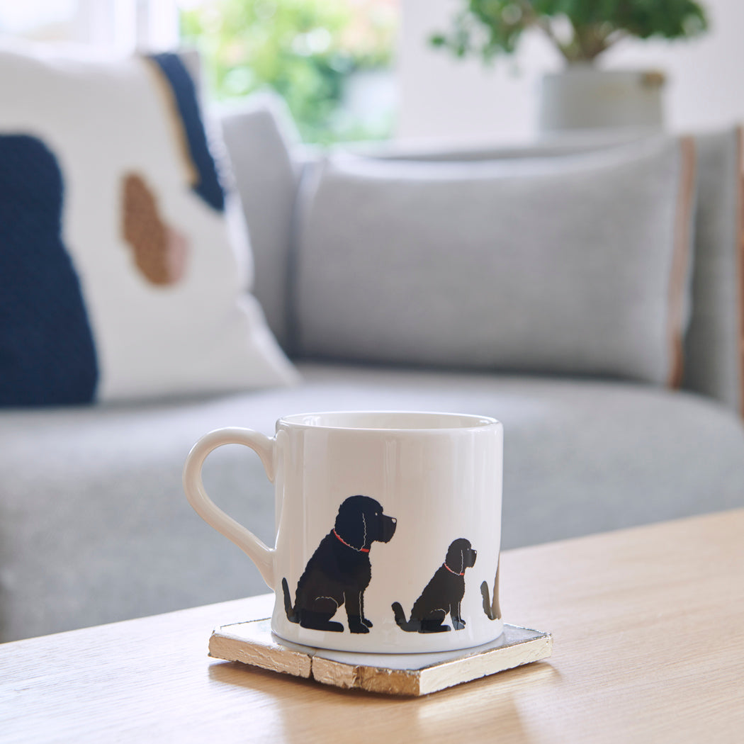 Sweet William Black Cockapoo Mug on a coffee table — illustrated Cockapoo repeat pattern ceramic mug
