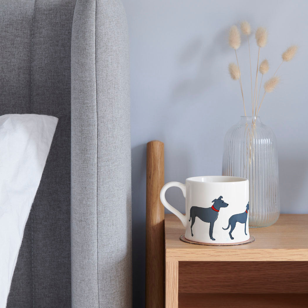 Sweet William Lurcher Mug on a bedside table — Lurcher dog lover gift mug