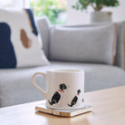 Sweet William Springer Spaniel (Black & White) Mug on a coffee table — illustrated repeat pattern ceramic mug