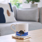 Swimming Black Labrador mug on a coffee table — ceramic dog lover gift by Sweet William Designs