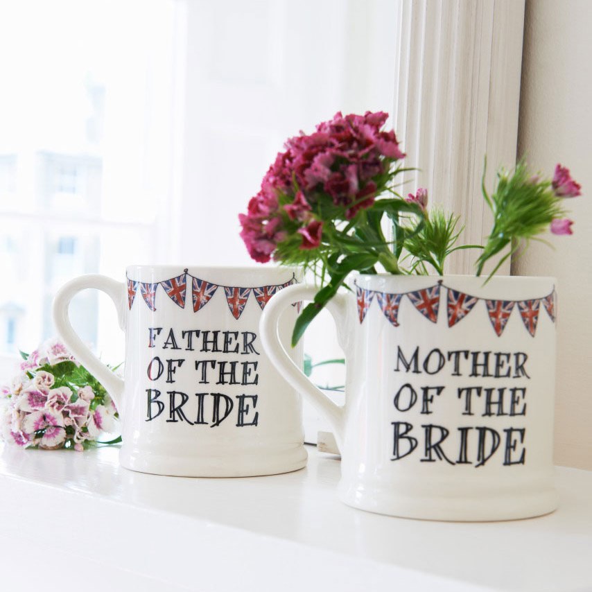 Father of the Bride and Mother of the Bride ceramic mugs shown side by side with flowers, a lovely keepsake gift for the bride’s parents