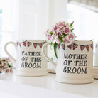 Father of the Groom and Mother of the Groom ceramic mugs shown side by side with flowers, a lovely keepsake gift for the groom’s parents