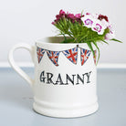 Ceramic Granny mug with hand-drawn Union Jack bunting, holding a bouquet of pink and white flowers, a thoughtful gift for a much-loved grandparent