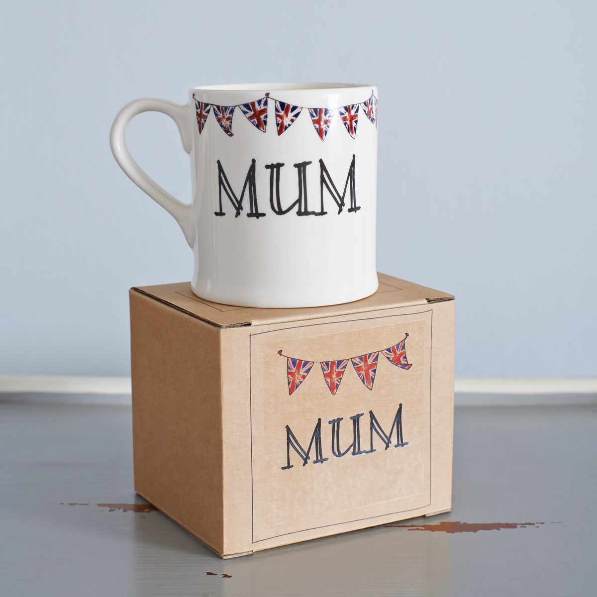 Ceramic Mum mug with hand-drawn Union Jack bunting, displayed on its kraft gift box from Sweet William Designs