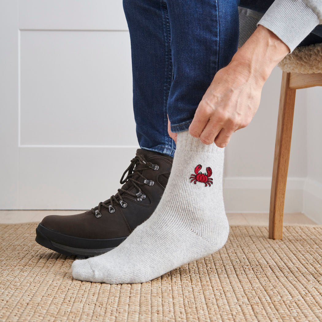 Man pulling on crab wool socks with walking boots — embroidered wool blend, unisex coastal gift by Sweet William Designs