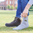 Man pulling on embroidered British 4x4 wool socks with walking boots indoors — unisex wool blend socks by Sweet William Designs
