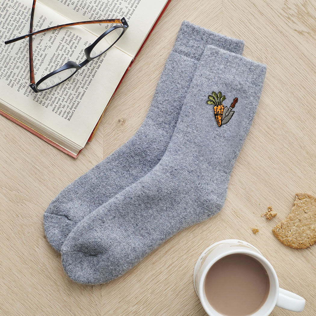 Carrots & Trowel gardening socks laid flat with book, glasses and cup of tea — embroidered wool blend socks, thoughtful gift for gardeners