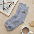 Golf buggy embroidered wool socks laid flat with book, glasses and cup of tea — thoughtful golf fan gift by Sweet William Designs