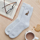 Hare embroidered wool socks laid flat with book, glasses and cup of tea — cosy hare lover gift by Sweet William Designs