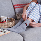Red tractor wool socks worn while relaxing — cosy countryside-inspired socks for countryside lovers by Sweet William Designs.