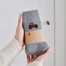 Tractor embroidered wool socks held in hands with Sweet William Designs branded band — soft wool blend countryside gift