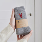 Lobster wool socks held in hands with Sweet William Designs packaging band — embroidered coastal gift for beach lovers
