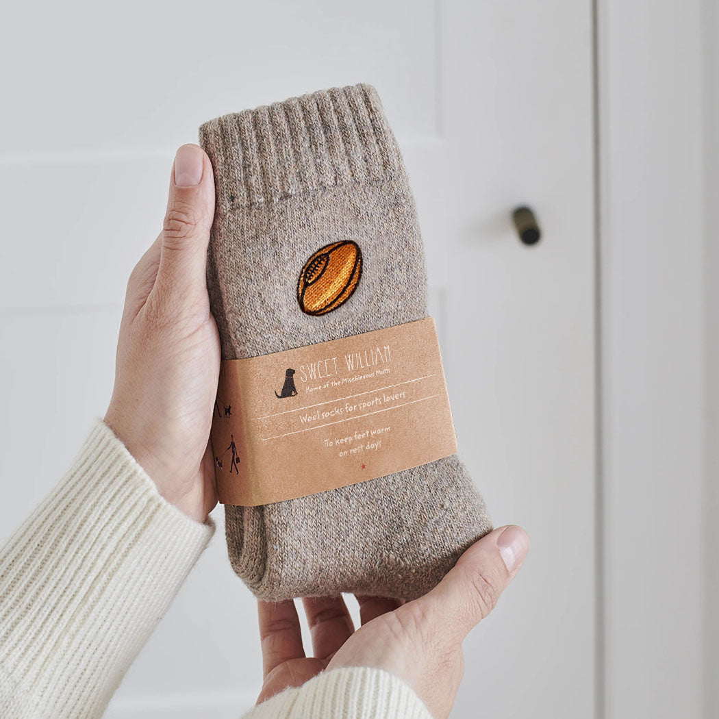 Rugby wool socks held in hands with Sweet William Designs branded band — soft wool blend rugby lover gift