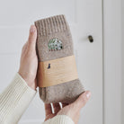 Greenhouse gardening socks held in hand — soft taupe marl wool blend with embroidered greenhouse design, gardening gift by Sweet William Designs