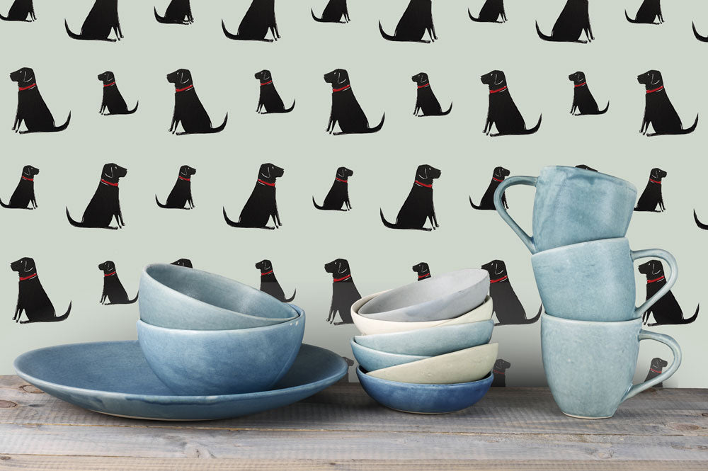 Sweet William Designs Black Labrador wallpaper with blue pottery styling — repeat Labrador pattern on sage green