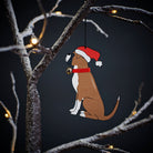 Boxer Christmas tree decoration hanging on lit winter tree — wooden dog decoration with Father Christmas hat and jingle bell collar by Sweet William Designs