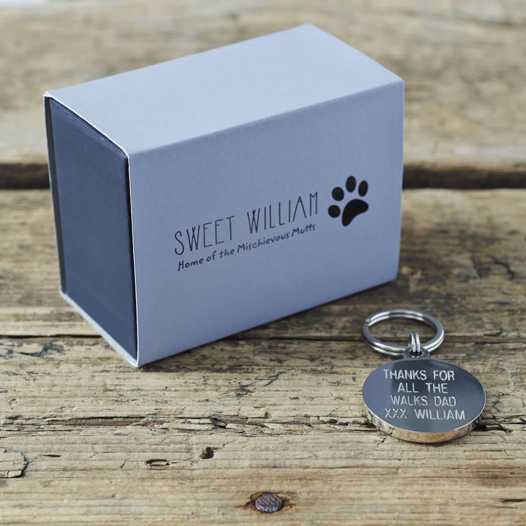 Personalised dog ID tag with engraved message alongside Sweet William Designs gift box — personalised dog tag, thoughtful dog lover gift