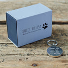 Personalised dog ID tag with engraved message alongside Sweet William Designs gift box — personalised dog tag, thoughtful dog lover gift