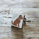 Close-up of personalised Chocolate Cockapoo / Labradoodle cufflink engraved with name on rustic wood — silver-plated gift for Cockapoo owners
