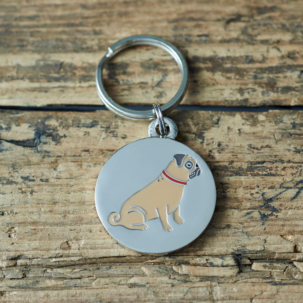 Close-up of Pug dog ID tag — silver-plated brass with illustrated Pug design, personalised dog tag by Sweet William Designs