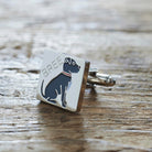 Close-up of personalised Staffie cufflink engraved with name on rustic wood — silver-plated gift for Staffie owners