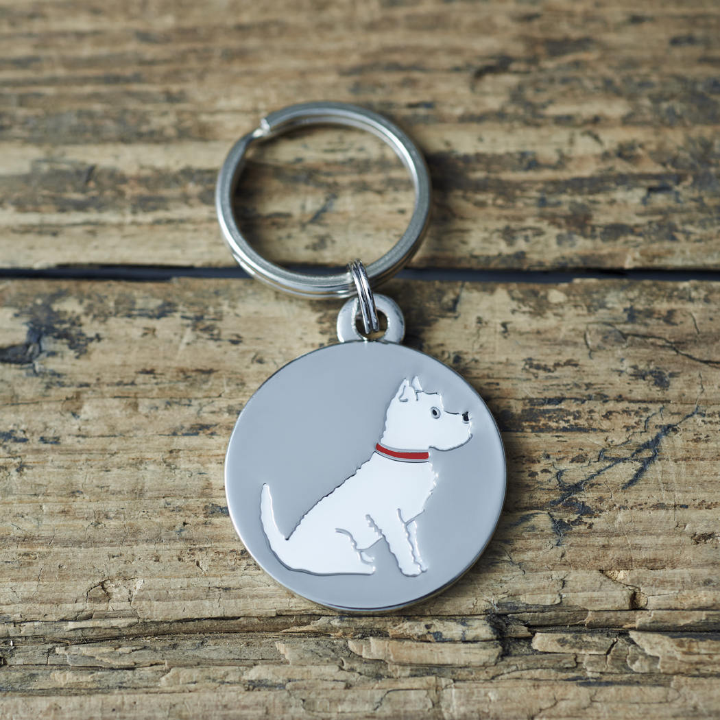 Close-up of Westie dog ID tag — silver-plated brass with illustrated Westie design, personalised dog tag by Sweet William Designs