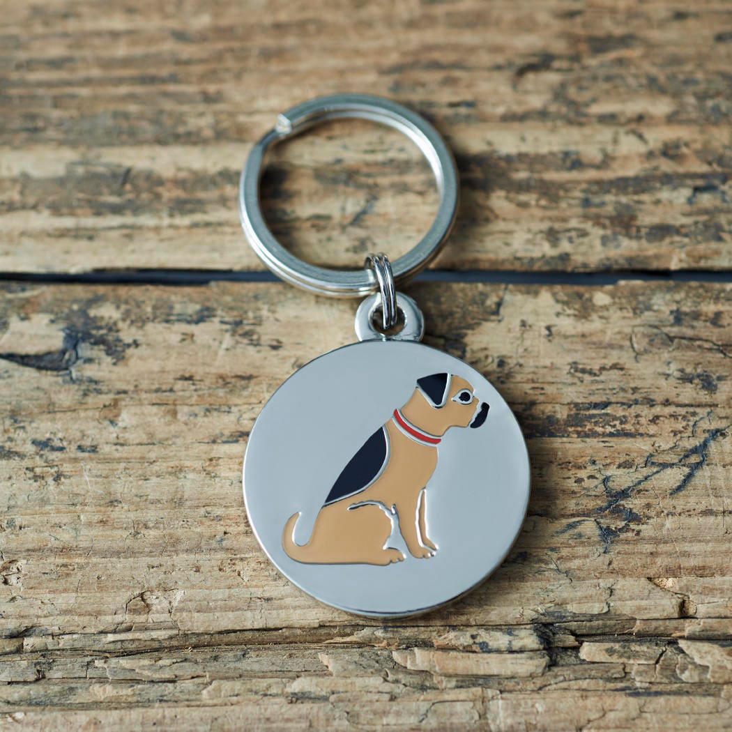 Close-up of Border Terrier dog ID tag — silver-plated brass with illustrated Border Terrier design, personalised dog tag by Sweet William Designs
