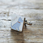 Close-up of personalised Westie cufflink engraved with name on rustic wood — silver-plated gift for Westie owners